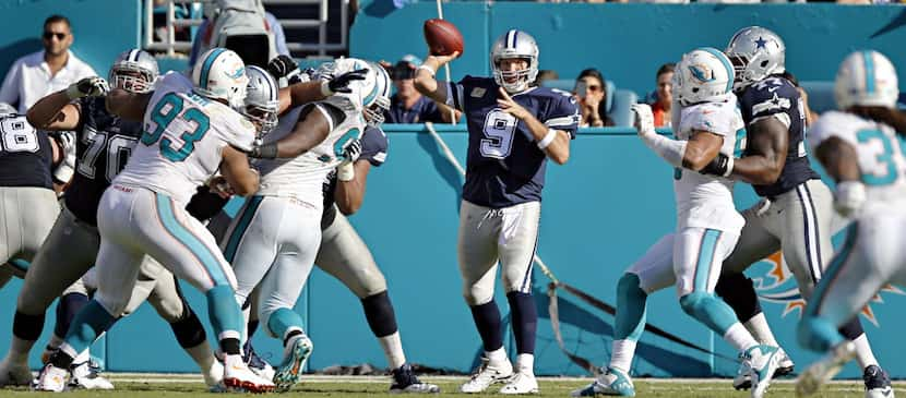 Dallas Cowboys quarterback Tony Romo (9) finds a hole in the Miami Dolphins defensive line...