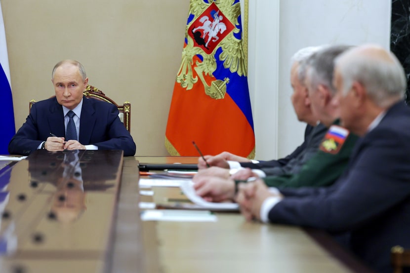 Russian President Vladimir Putin, left, speaks during a meeting with the leadership of the...