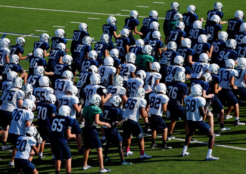 V.R. Eaton High School football players form lines as they do a team exercise during...