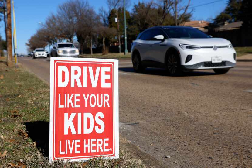 Traffic passes by a cautionary sign posted along Mockingbird Lane in Dallas. 