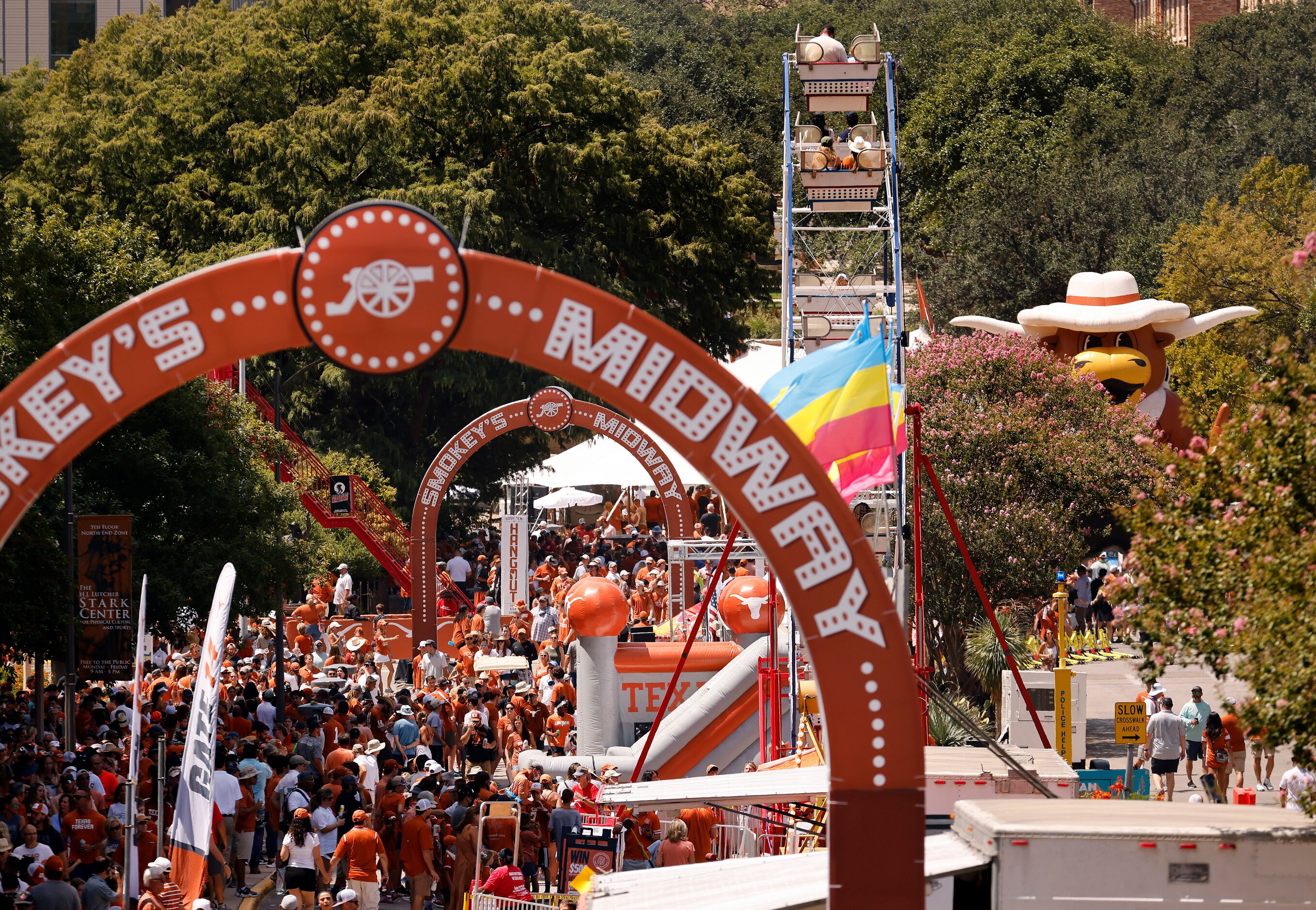 Fans fill Smokey's Midway and ride the ferris wheel outside of DKR-Texas Memorial Stadium in...