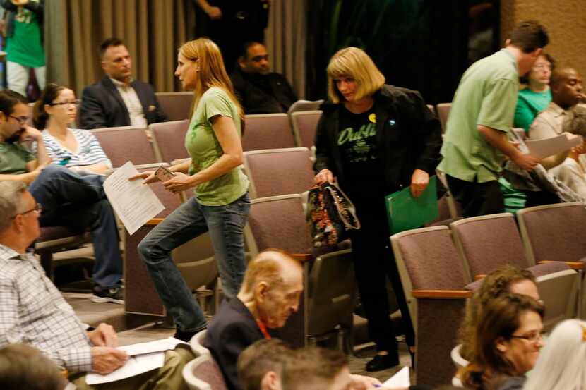  Ordinance opponents Linda Jackson (center, in green) and Nancy Starnes leave after the city...