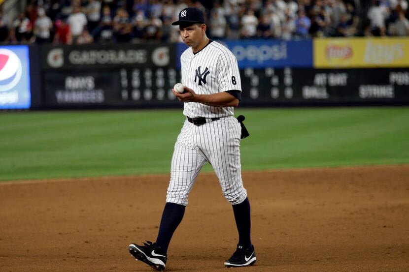 New York Yankees' Alex Rodriguez walks towards third base with the game ball after the...