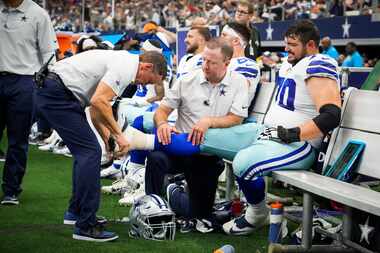 Dallas Cowboys guard Zack Martin has his ankle taped on the sidelines during the second half...