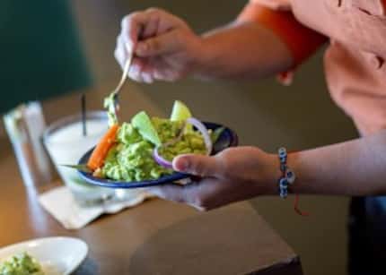  A Tex-Mex staple, fresh guacamole, is served onto a customer's plate at Mesero Prestonwood....