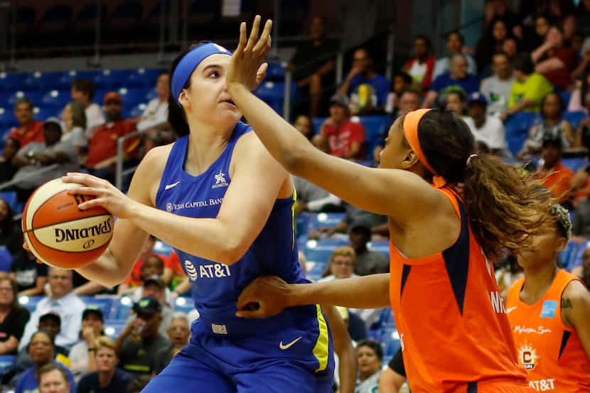 Dallas Wings forward Megan Gustafson (13), left, looks to shoot as she is defended by the...