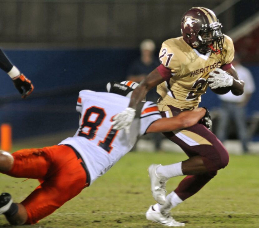 Frisco Heritage senior Sean Jones (21) drives past Frisco Wakeland sophomore Tanner Euting...