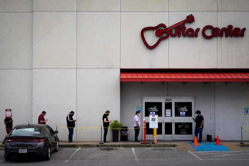Customers kept social distancing as they waited to enter the Guitar Center store at 7814 N....