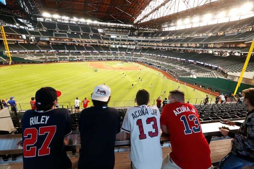 Fanáticos de los Atlanta Braves  observan el campo de juego del Globe Life Field en...