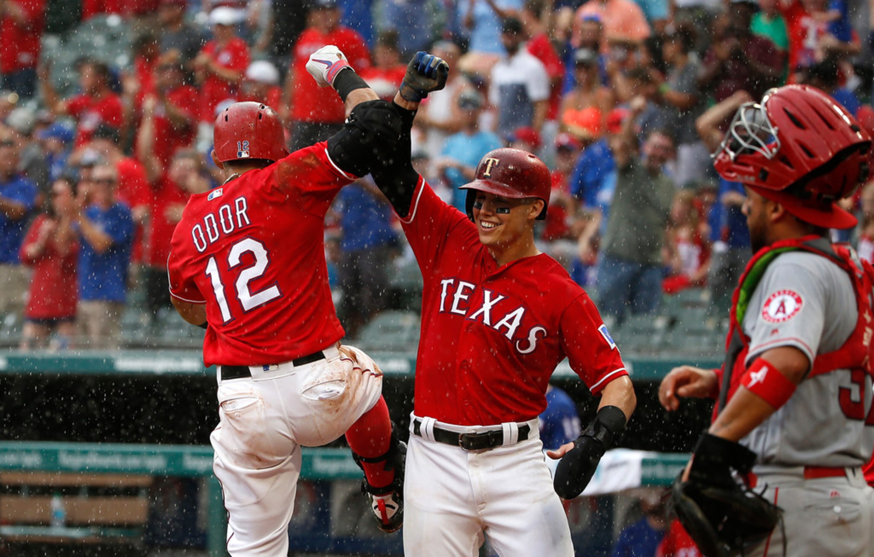 ARLINGTON, TX - AUGUST 19: Rougned Odor #12 of the Texas Rangers celebrates with teammate...