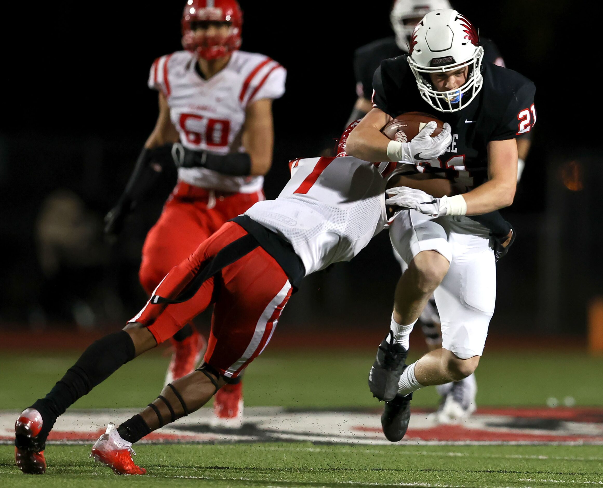 Argyle running back Peyton Shoemake (21) is brought down after a nice gain by Terrell...