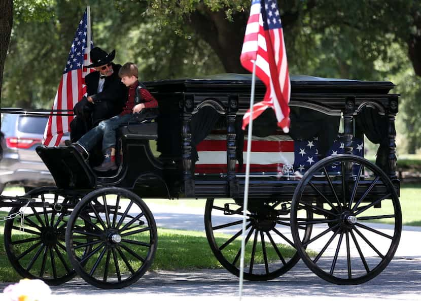 Magnus Ahrens, 8, son of fallen Dallas police Senior Cpl. Lorne Ahrens sits with the driver...