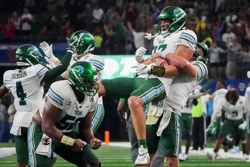 Tulane quarterback Michael Pratt lifts tight end Alex Bauman (87) in celebration after a...