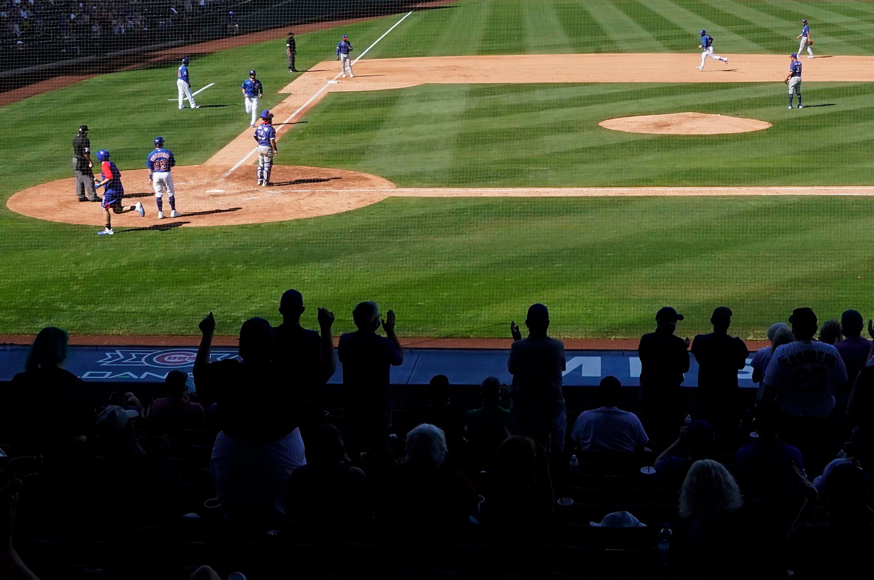 Chicago Cubs fans cheer a grand slam home run by Cubs designated hitter Javier Baez off of...