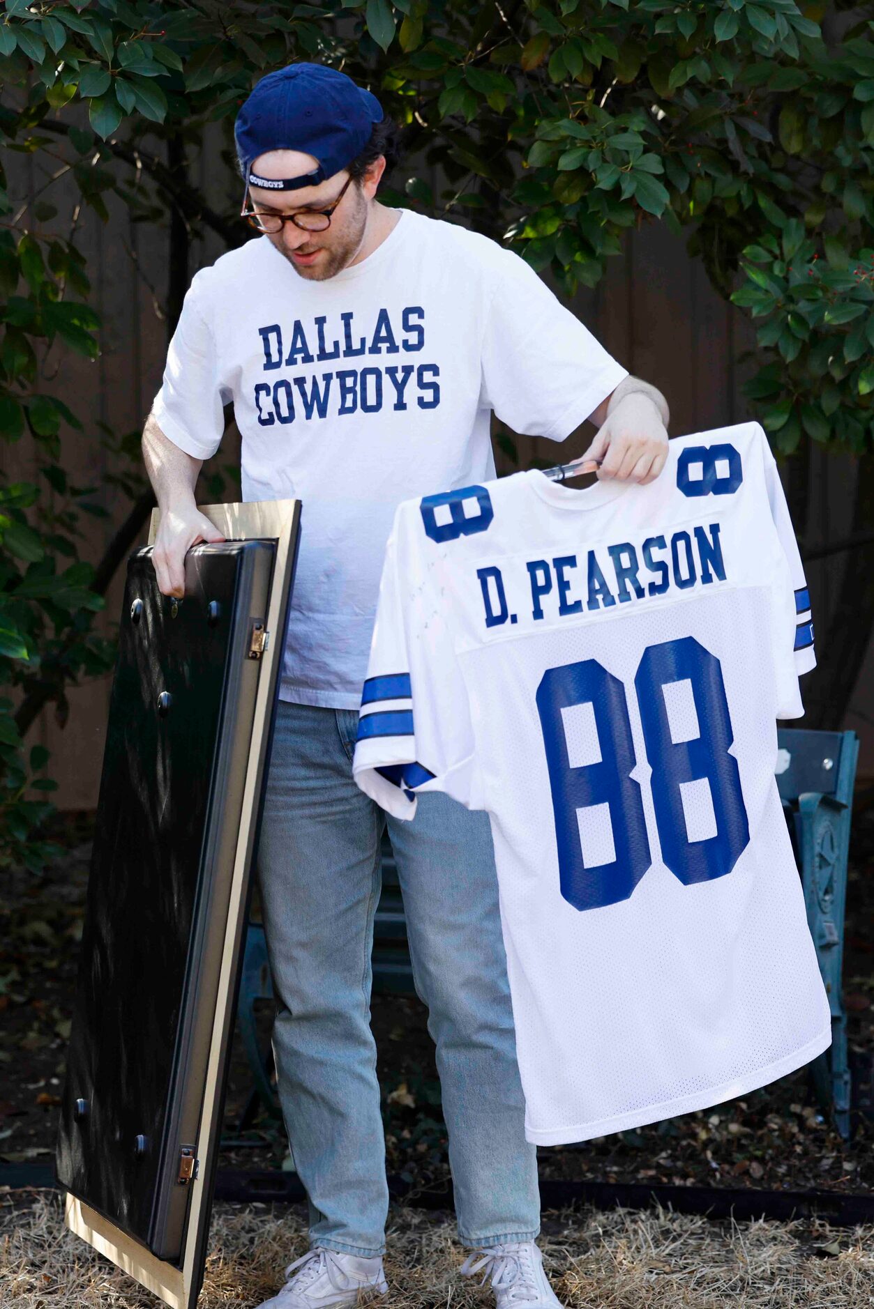 Cowboys fan Miles Andres puts back the jersey into the frame after a portrait session at...