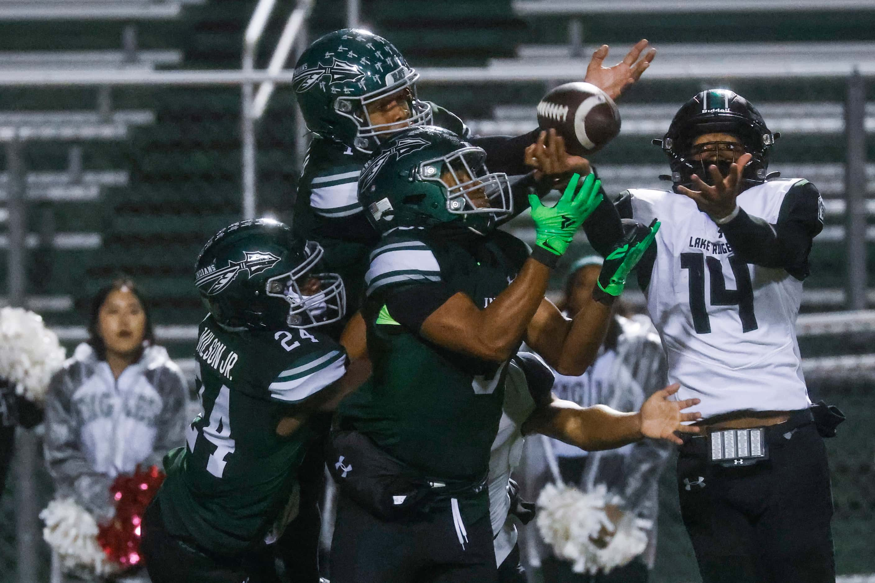 Waxahachie’s Donniel Wilson Jr. (24), left, Keith Abney II (1), top, and Gregory Hatley III...