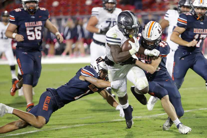 Lone Star player #2, Ashton Jeanty, is brought down by Wakeland players #1, Davion Woolen,...