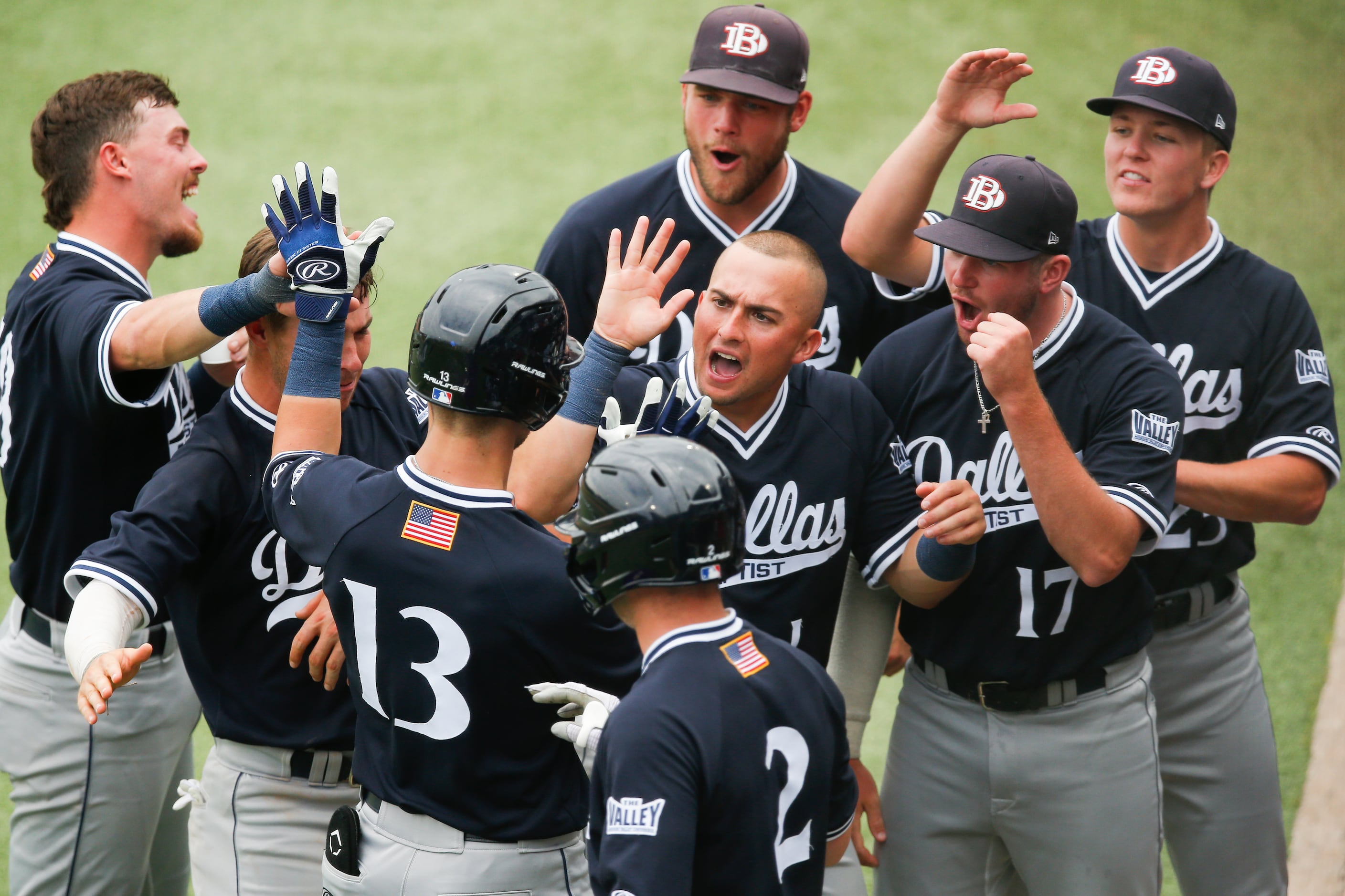 DBU’s Andrew Benefield (13) is congratulated by teammates after hitting a solo home run in...
