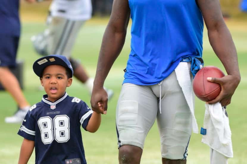 Dallas Cowboys receiver Dez Bryant walks off the field with his son, Dez Bryant, Jr. after...