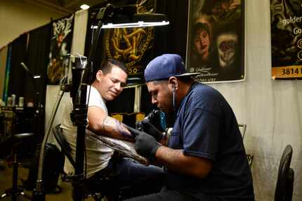 Gustavo Briseno,(der.) tatúa a Manuel Guerra, de 33 años de edad, residente de Arlington, el...