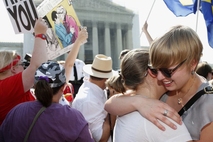 American University students Sharon Burk, left, and Molly Wagner, embrace outside the...