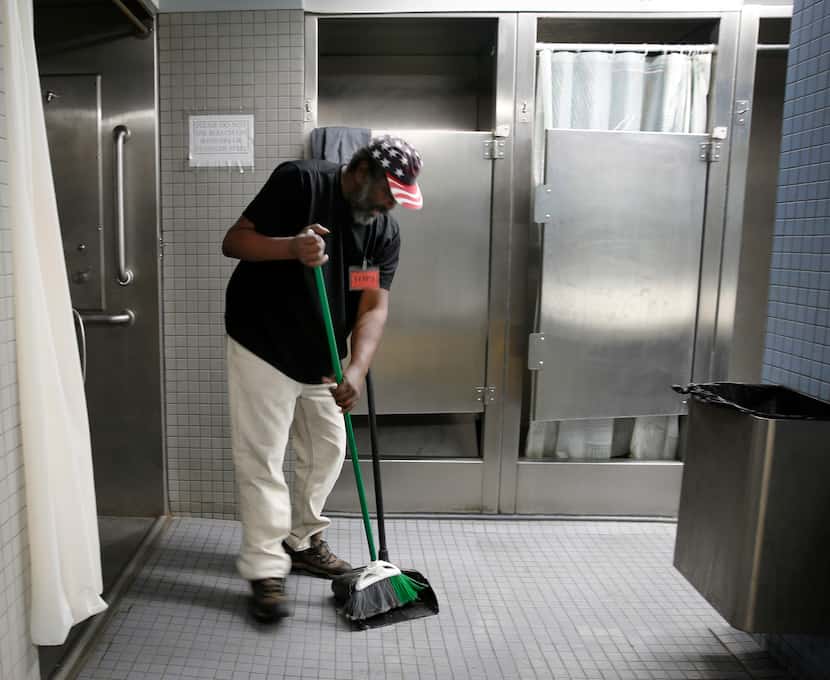Salvation Army volunteer Kenneth Spencer cleans up the men's showers at the Carr P. Collins...