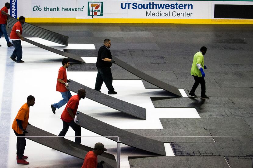 Workers convert the arena after a Dallas Stars hockey game in preparation for an NBA...