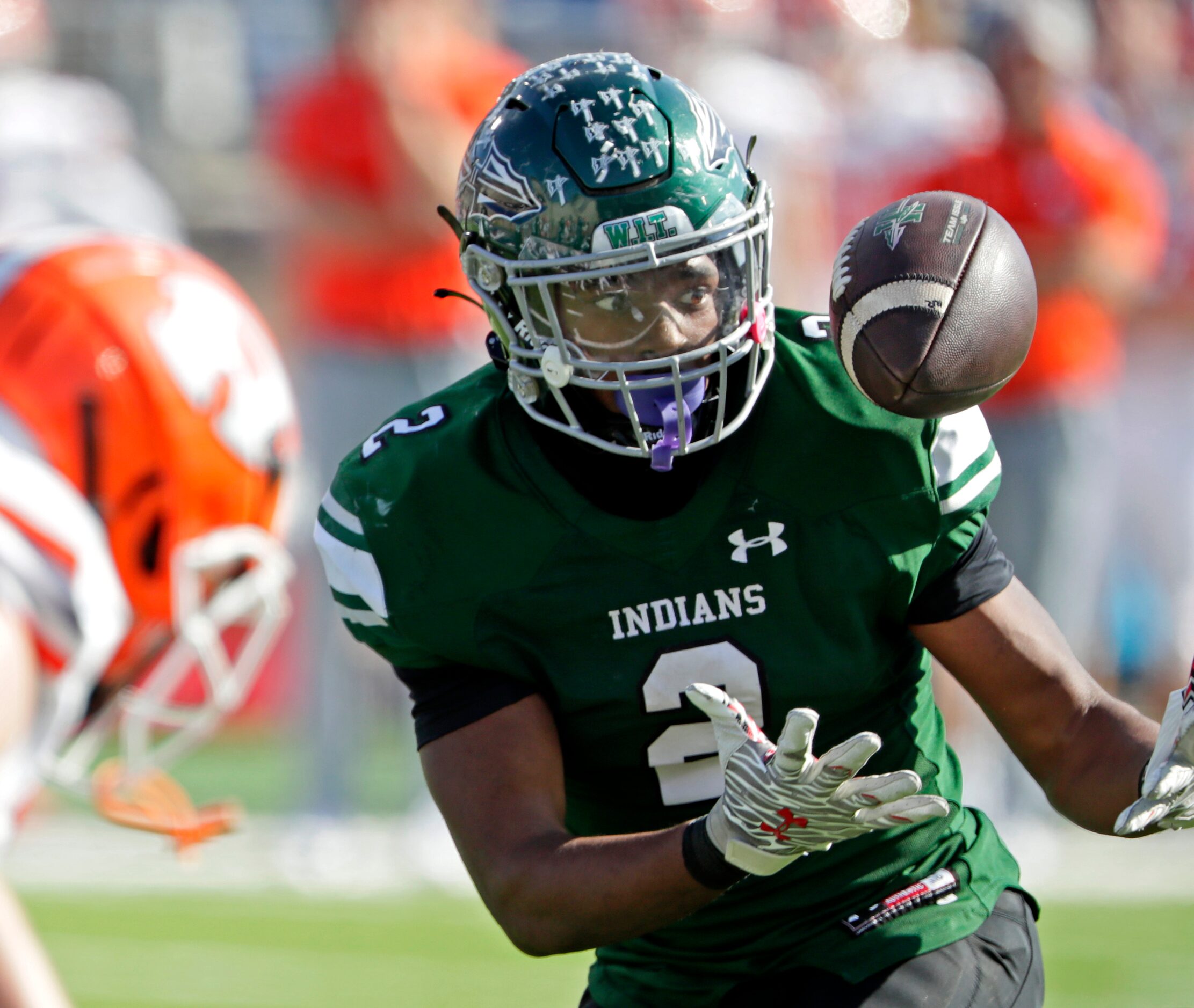 Waxahachie High School quarterback Wade Lemons (2) bobbles the snap during the first half as...