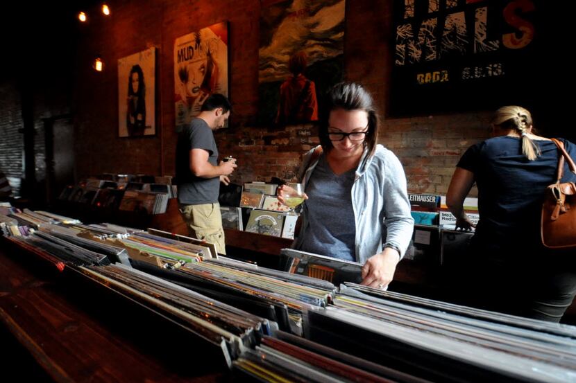Amy McCleary browses through records with a drink in hand at Off The Record in Deep Ellum,...