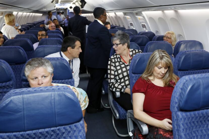 American Airlines and US Airways employees settled in aboard a charter flight Tuesday at...