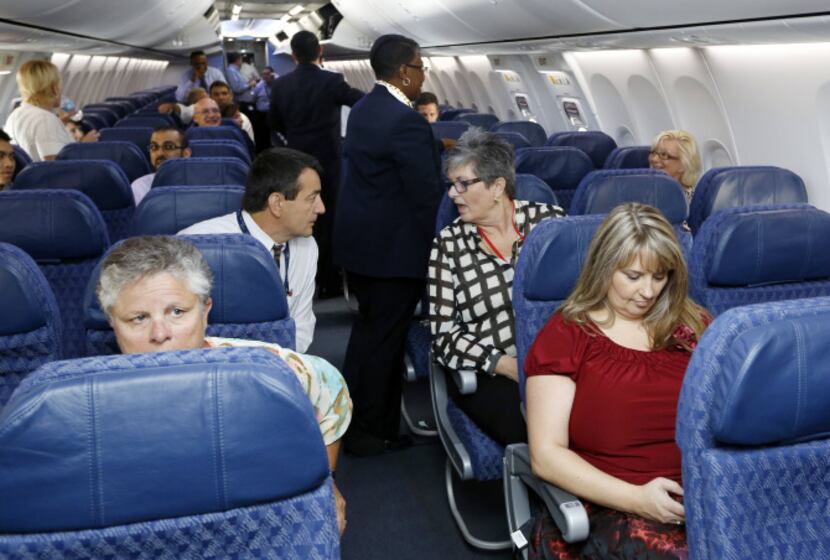 American Airlines and US Airways employees settled in aboard a charter flight Tuesday at...