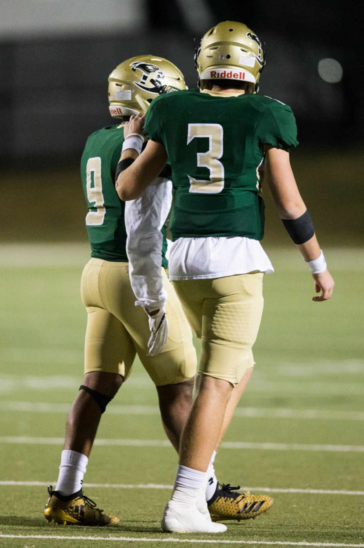 Birdville quarterback Stone Earle (3) puts his hand on the shoulder of running back...