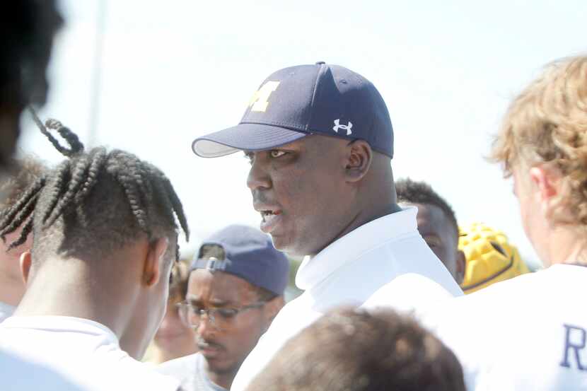 McKinney head football coach Marcus Shavers speaks with his players after their...