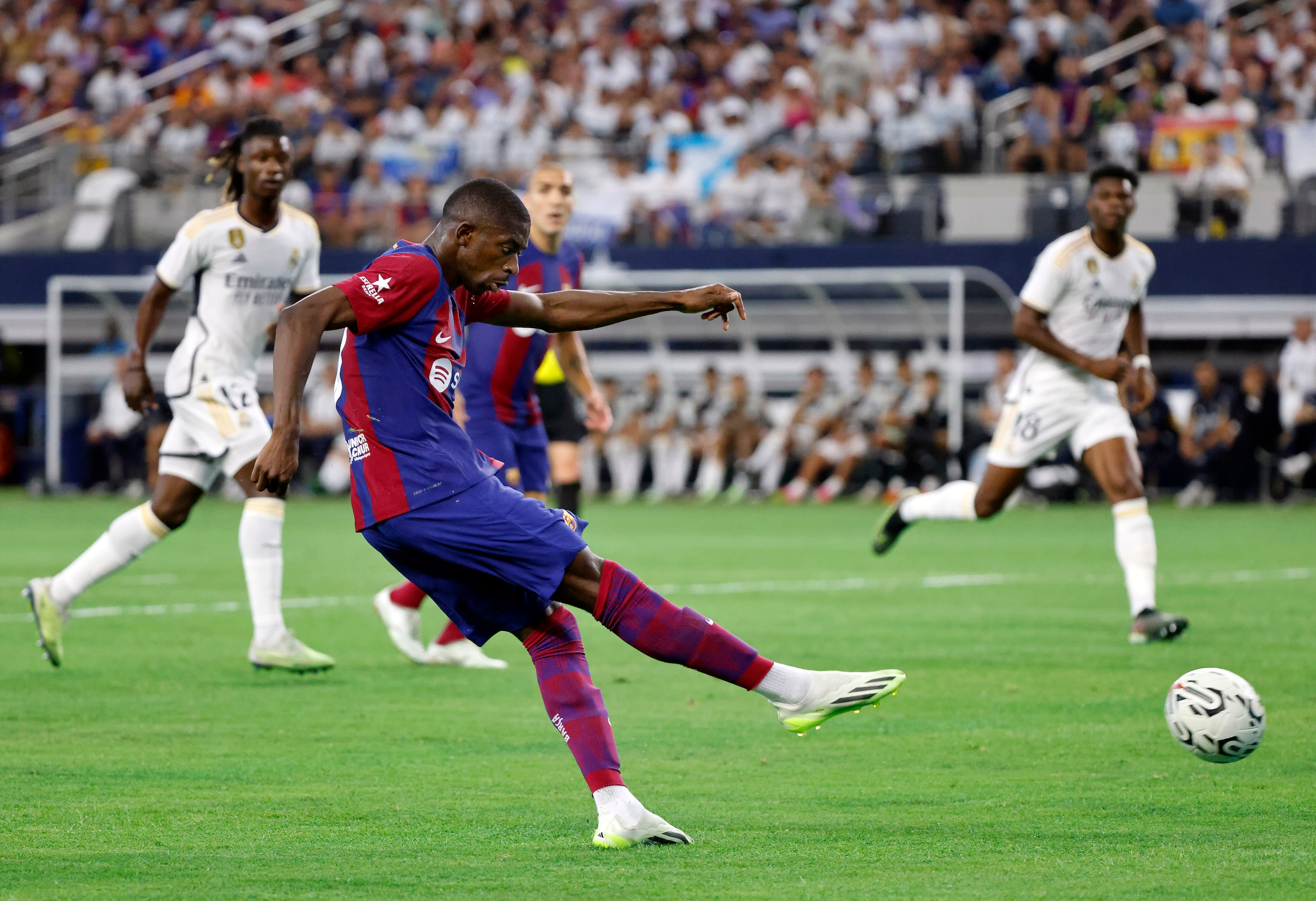 Barcelona forward Ousmane Dembélé (7) shoots and scores on Real Madrid goalkeeper Thibaut...