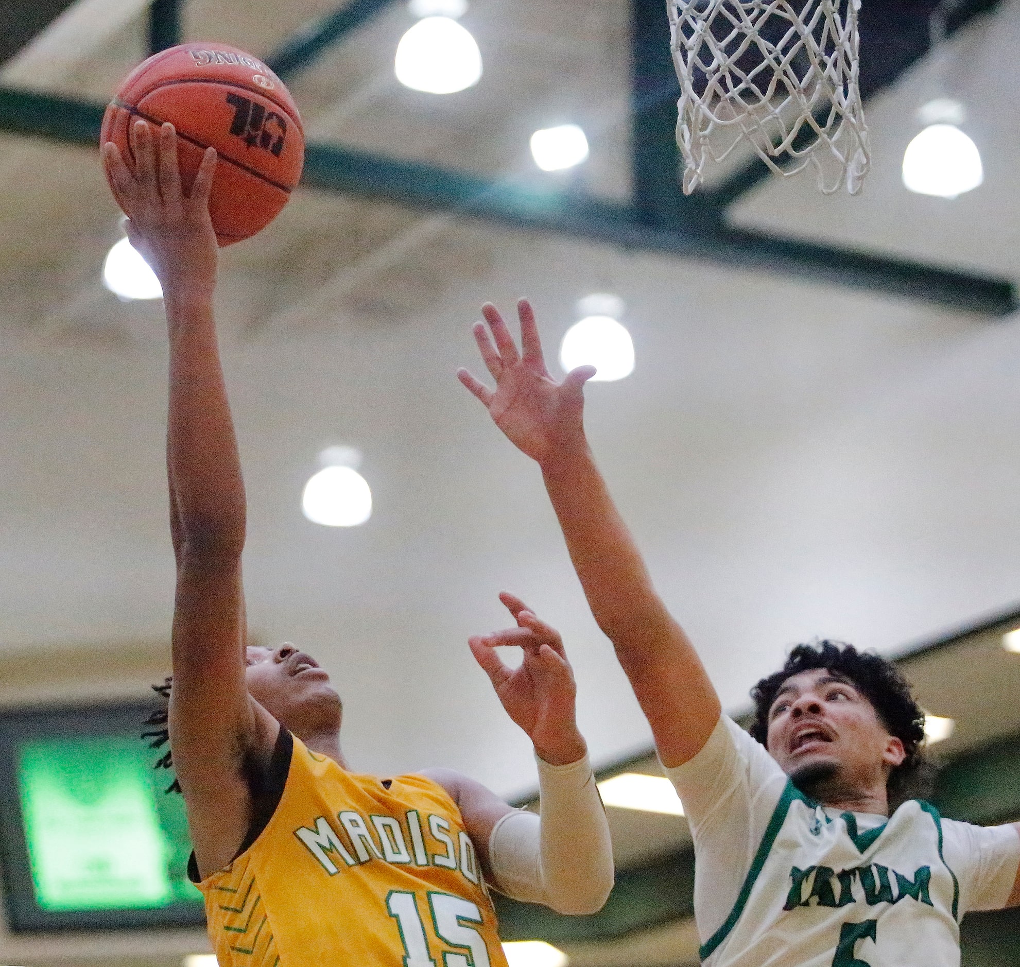 Madison forward Larell Wright (15) attempts a shot while Tatum guard Kendric Malon (5)...