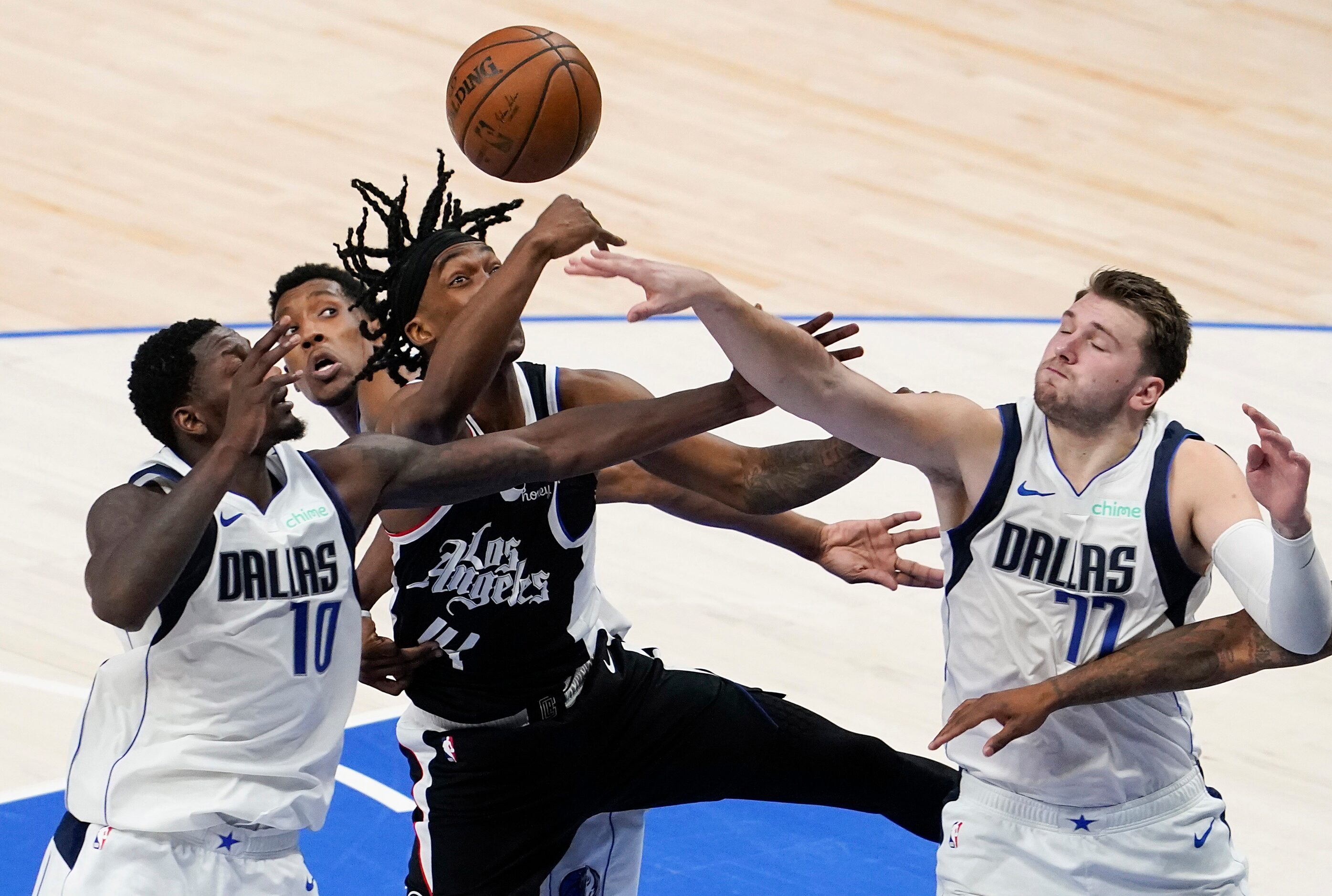 Dallas Mavericks guard Luka Doncic (77) an forward Dorian Finney-Smith (10) fight for...