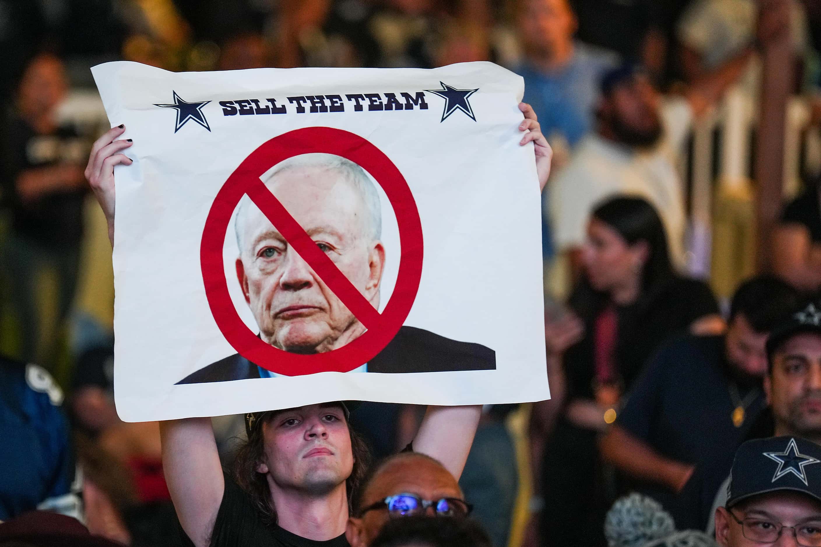 A fan holds up a sign calling for Dallas Cowboys owner and general manager Jerry Jones to...