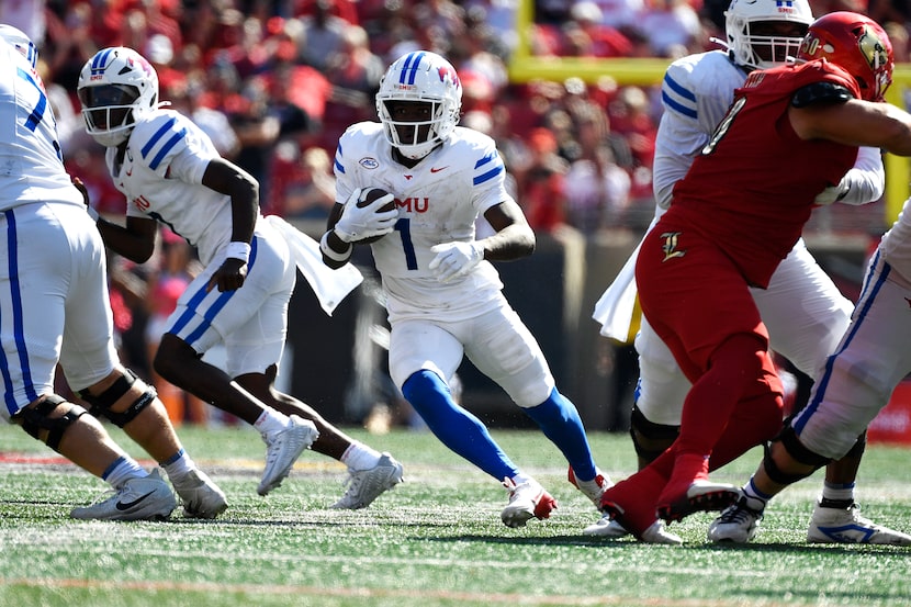 SMU running back Brashard Smith (1) runs through an opening in the Louisville line during...