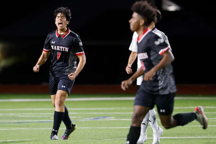James Martin High School midfielder Joel Romero (left) reacts after winning a soccer game...