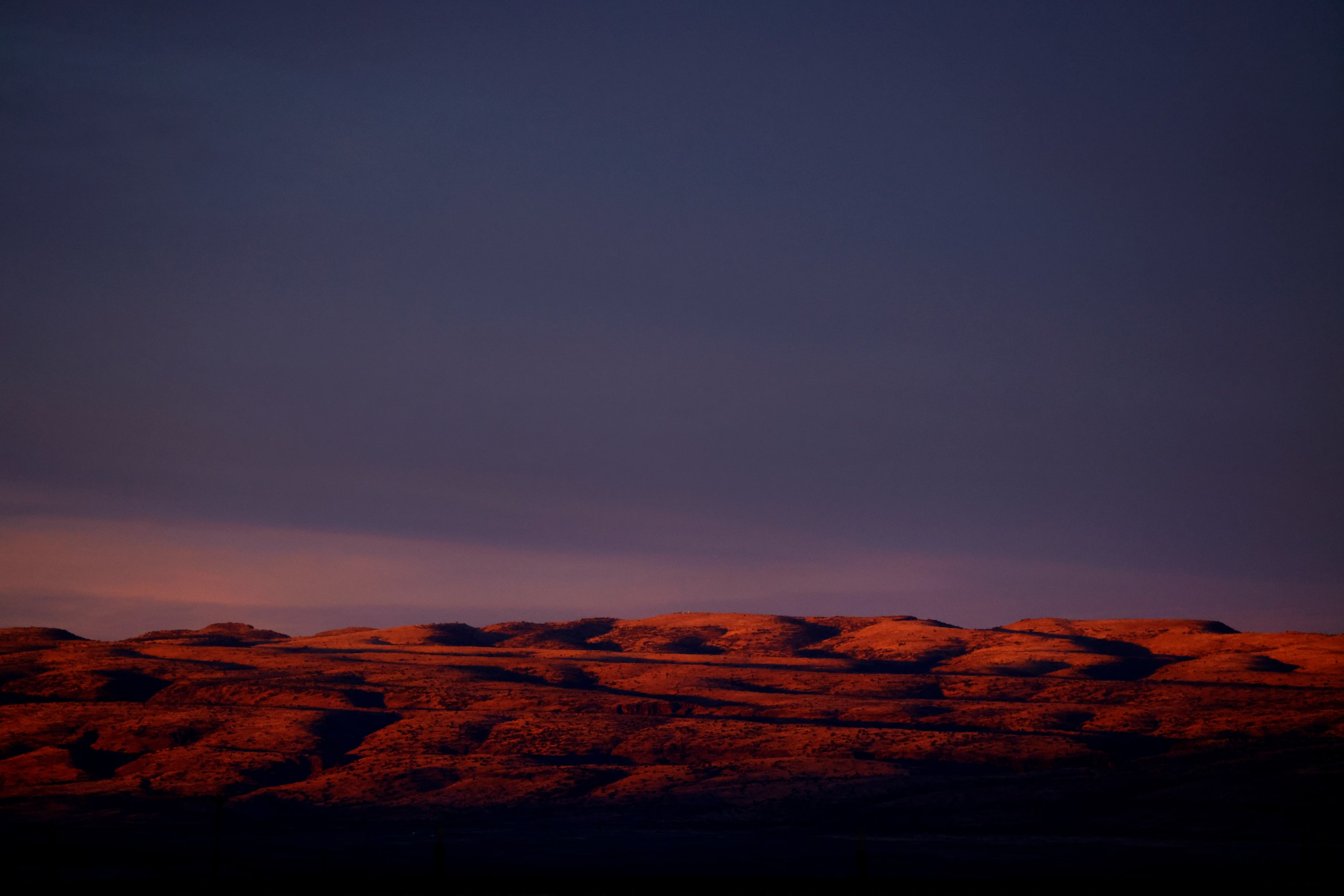 The rising sun cats shadows across the hills near Valentine, Texas, March 22, 2023.