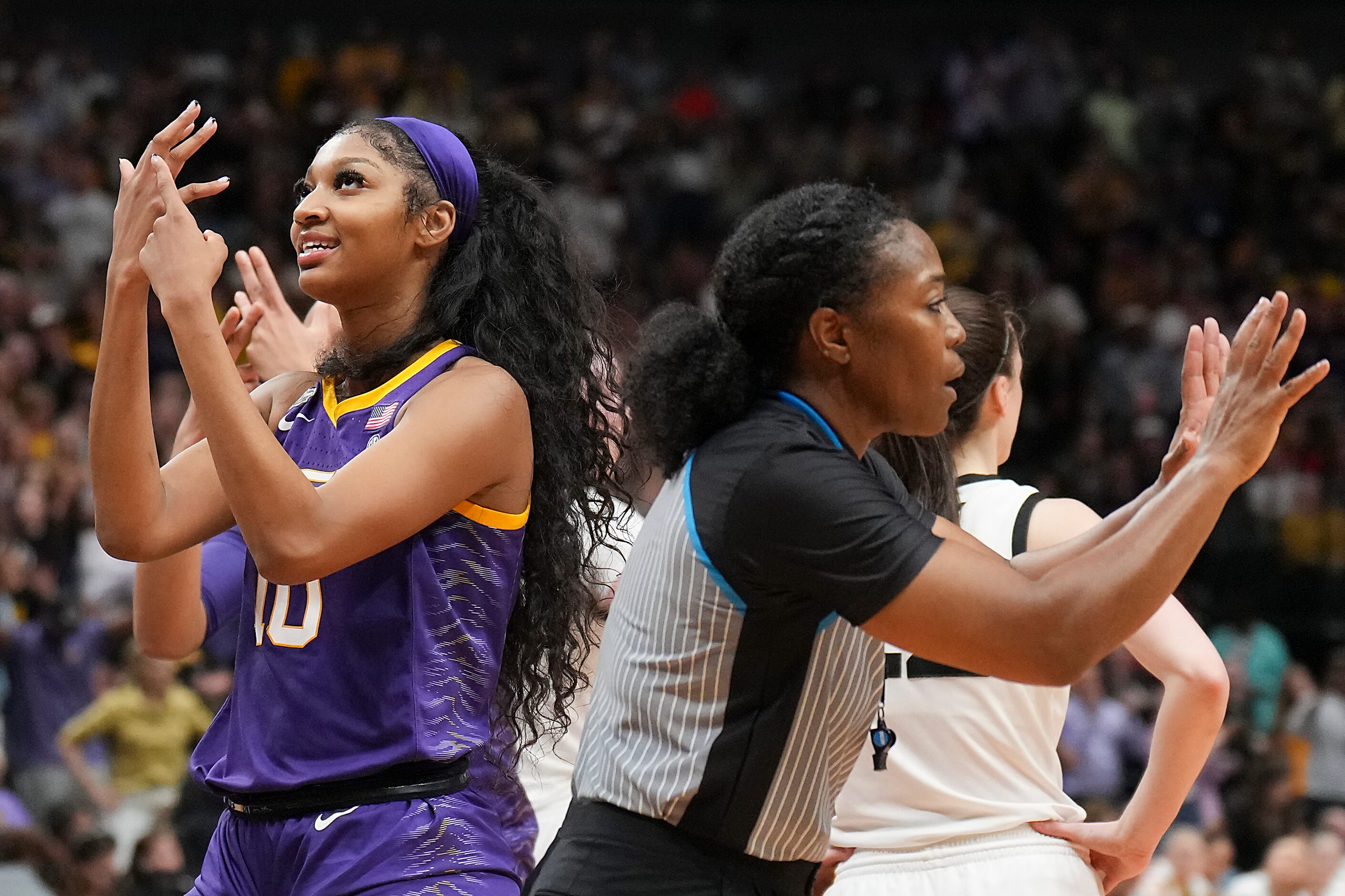 LSU forward Angel Reese points to her ring finger during the second half of the NCAA Women's...