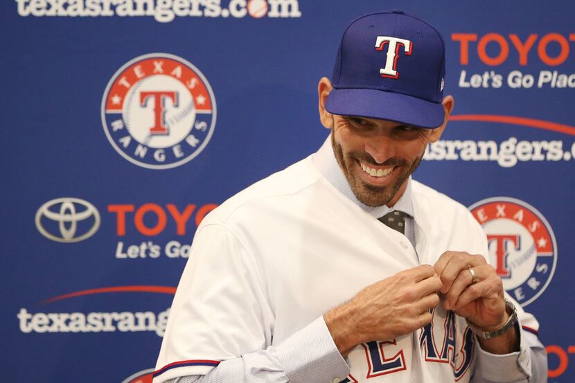 Texas Rangers' new manager Chris Woodward puts on a Texas Rangers jersey during a press...