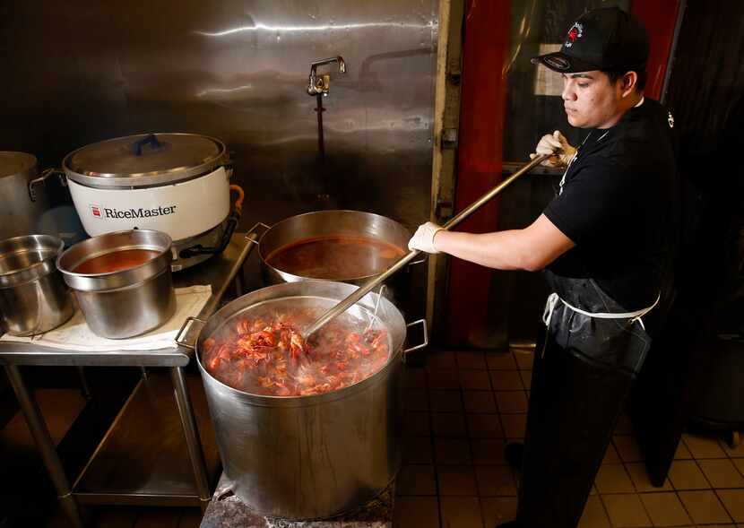 Juan G., a cook, stirs crawfish in the boiler at The Boiling Crab in Dallas.
