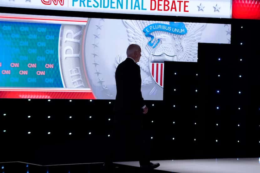 President Joe Biden walks from the stage during a break in a presidential debate with...