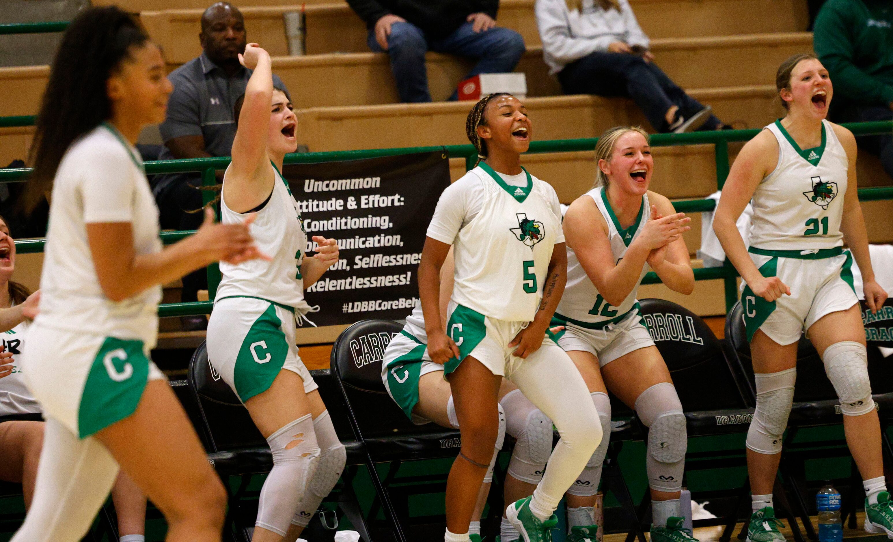 Southlake Carroll’s players cheer during the second half of a high school basketball game...