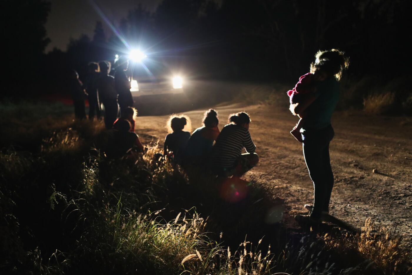 Border Patrol agents arrive to detain a group of Central American asylum seekers near the...