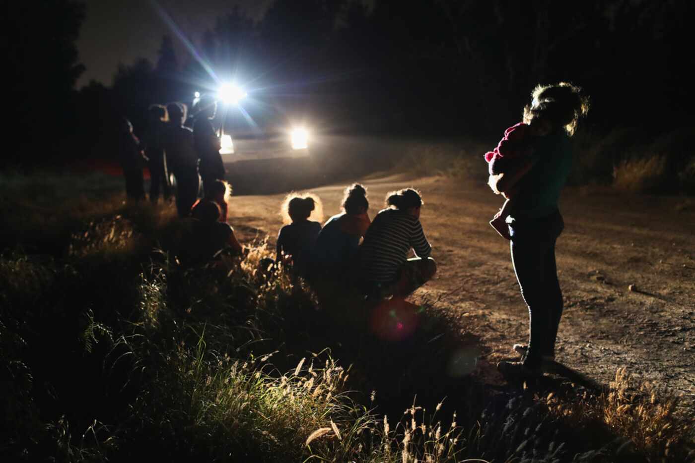 Border Patrol agents arrive to detain a group of Central American asylum seekers near the...