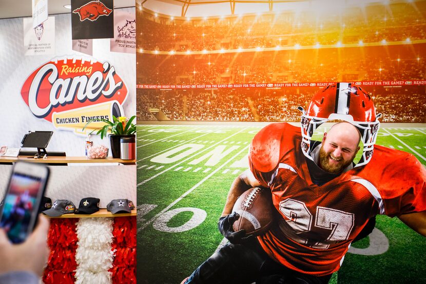 Employee Andrew Ross poses for a photo in a football display that fills the lobby at the...