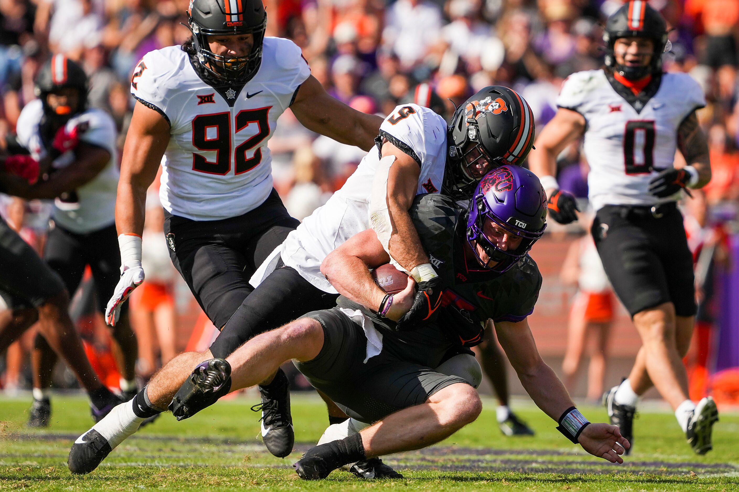 TCU quarterback Max Duggan (15) is dropped for a loss by Oklahoma State defensive end Brock...