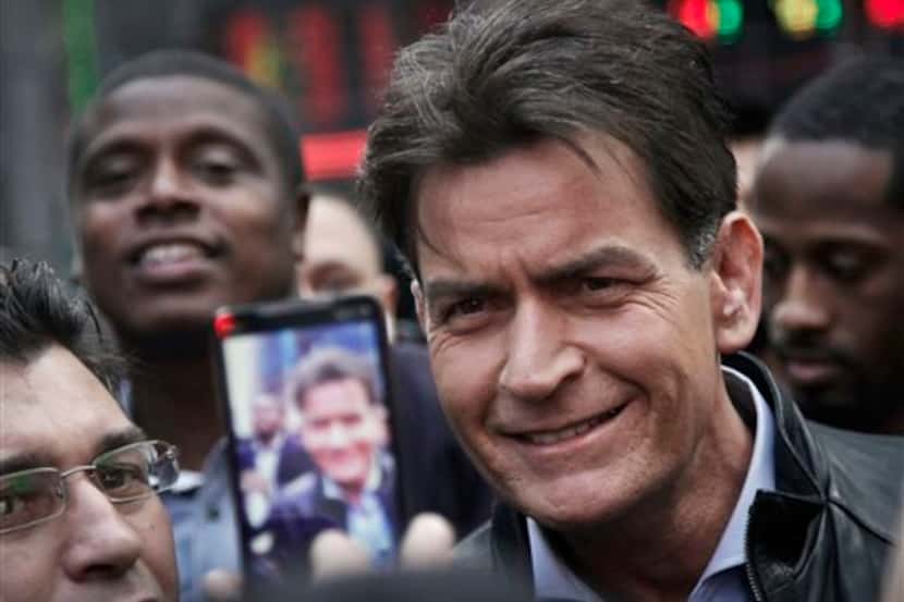 In this Monday, Jan. 14, 2013, file photo, actor Charlie Sheen is mobbed for autographs and...